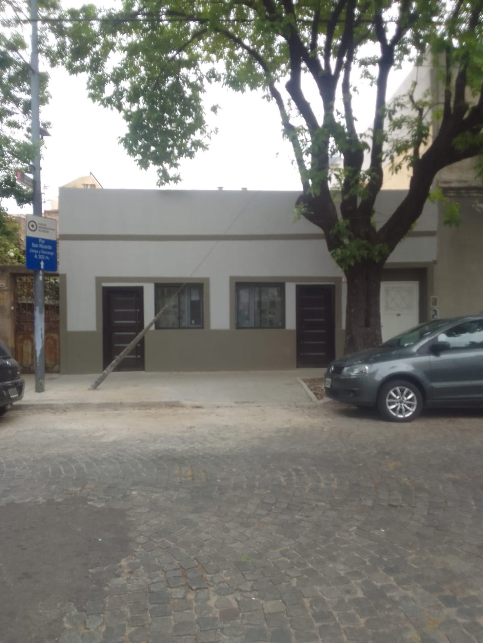Fachada de edificio moderno con árbol y autos — proyecto Departamentos para turistas en Barracas, por Arquitecto Guido Niccoli, en Barracas